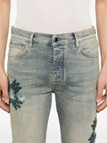Détail des applications décoratives sur le Amiri Ma Quad Applique Skinny Jeans Blue